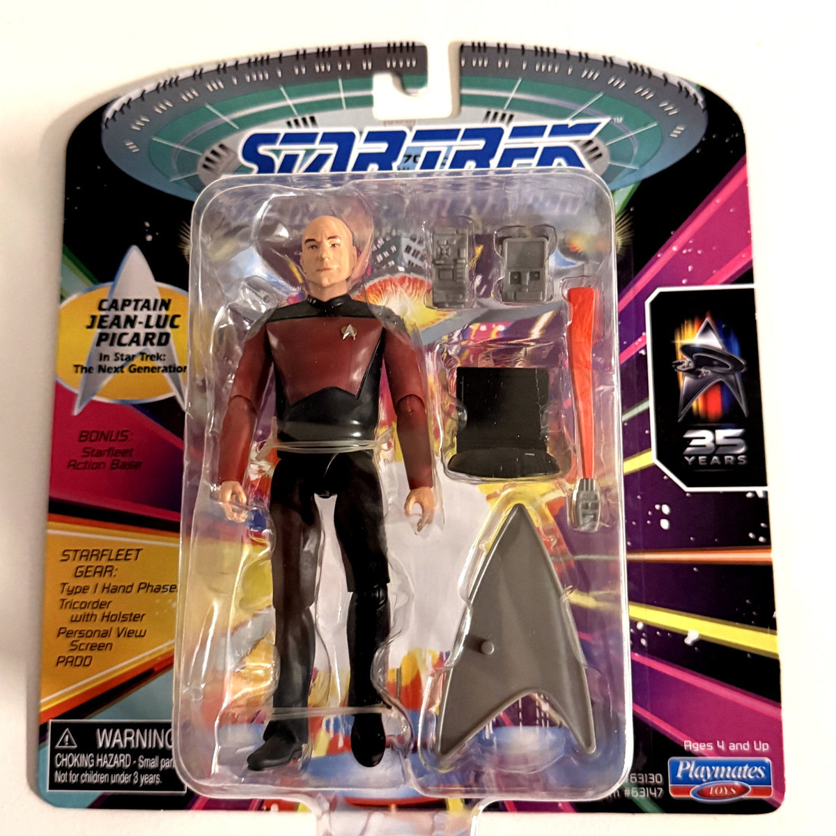 Front of the card showing Picard with phaser, tricorder, PADD, view screen and Starfleet base