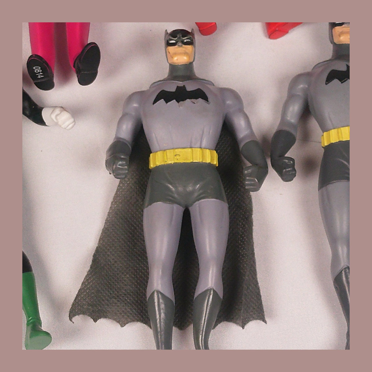 Bendable Batman figures with fabric capes, close-up